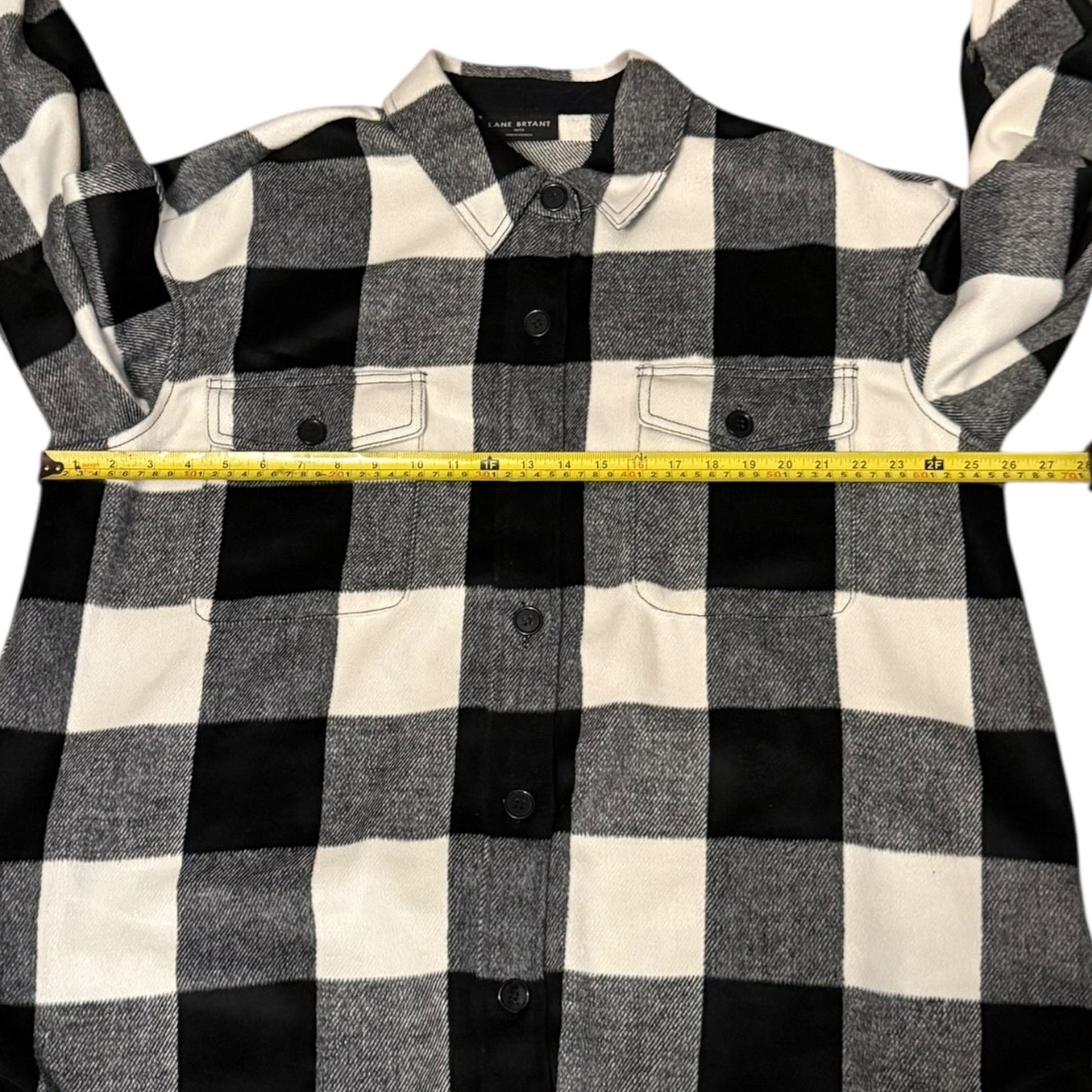 Black and white checkered shirt with a measuring tape for size reference on a white background