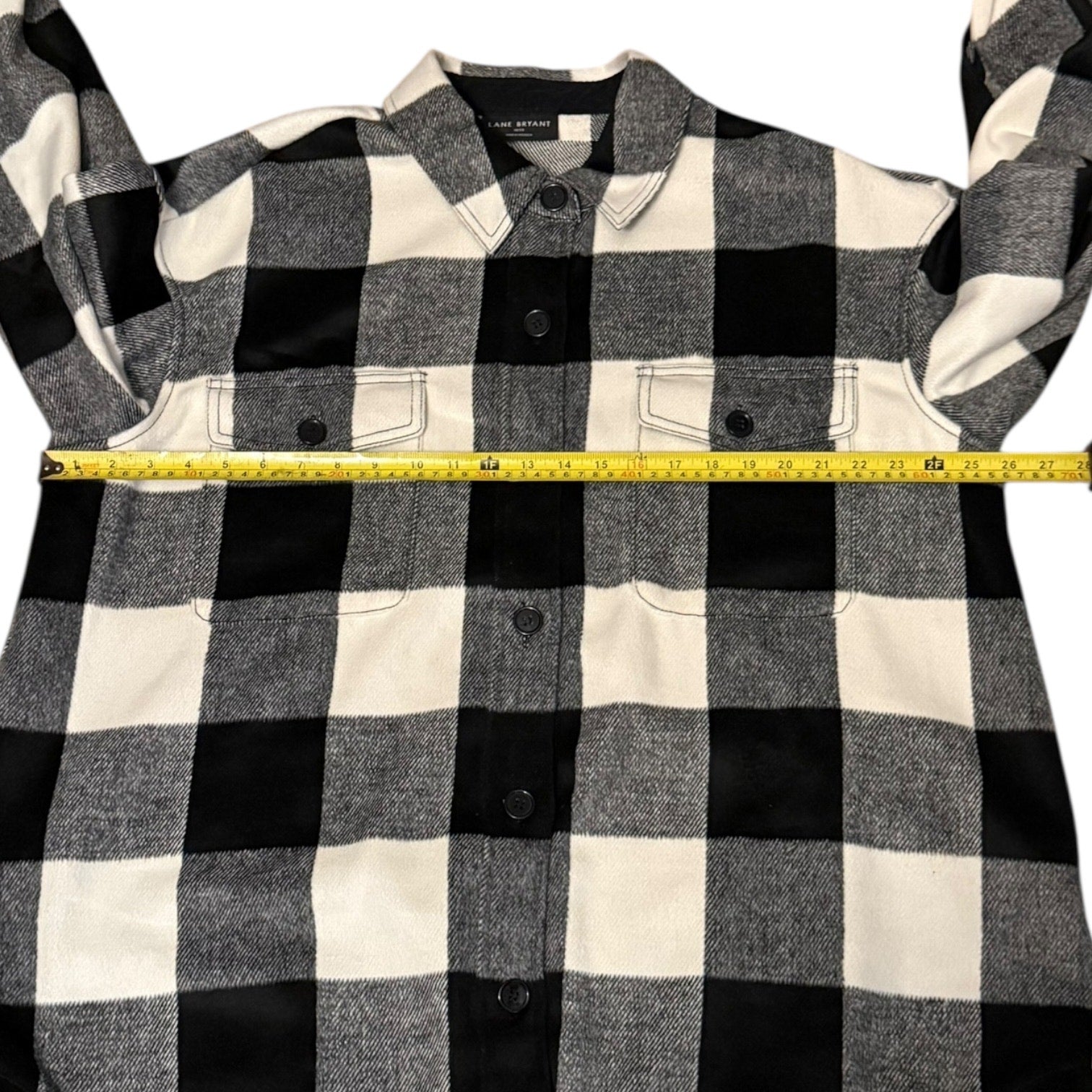 Black and white checkered shirt with a measuring tape for size reference on a white background