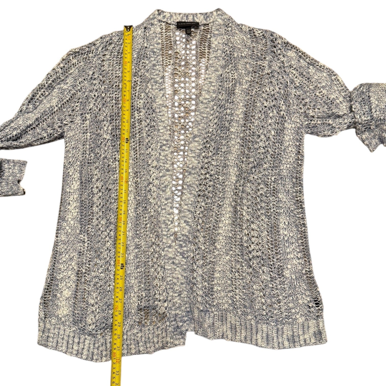 Blue cardigan with a measuring tape on a white background