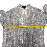 Blue knit front cardigan with a measuring tape across it on a white background