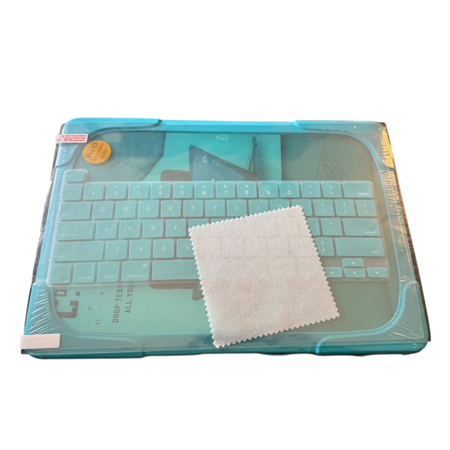 A protective keyboard skin and matching dust cloth set for a laptop, shown in its clear plastic packaging with a light blue protective cover.