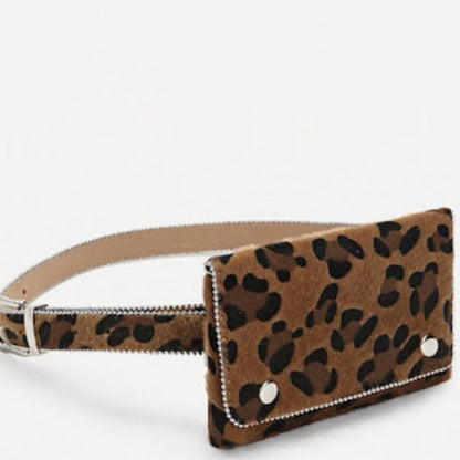 A leopard print belt bag with a brown and black spotted pattern, featuring a silver-tone buckle, and decorative silver rivets on a white background.