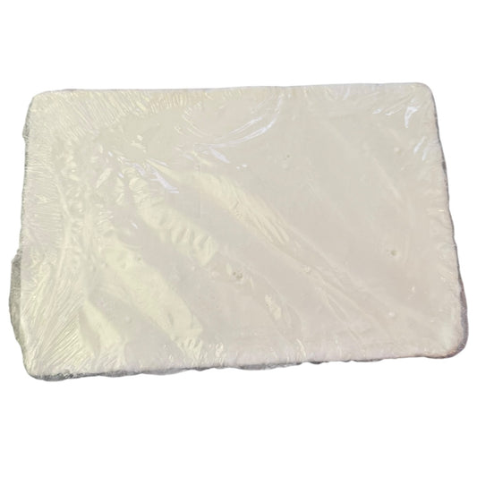 A rectangular white bloc
/ slab soap wrapped in clear plastic, shown on a plain white background.