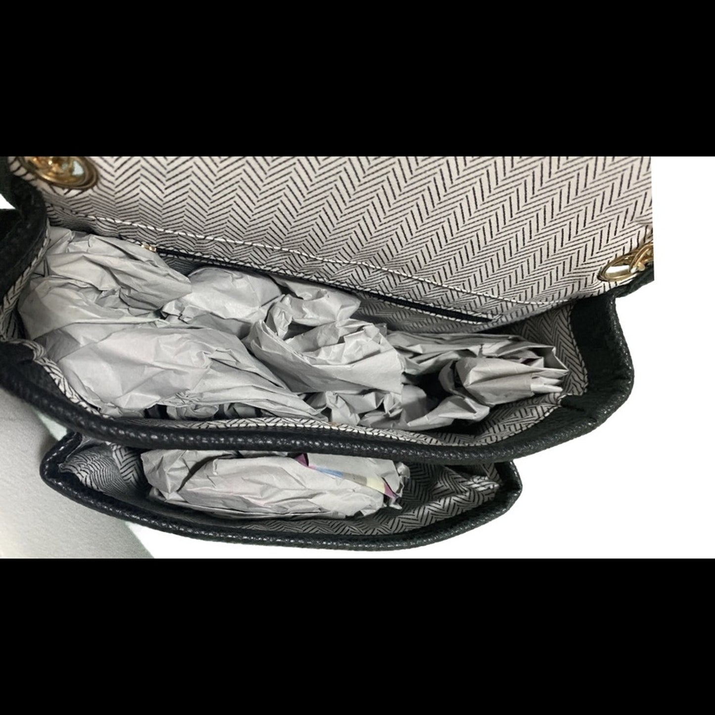 Open handbag with crumpled paper inside on a white background