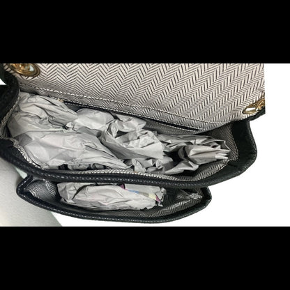 Open handbag with crumpled paper inside on a white background