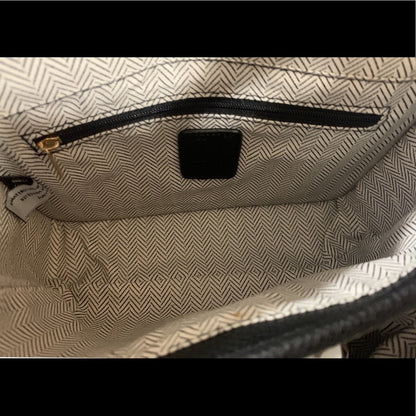 Close-up of a textured bag interior with a zipper and visible brand label.