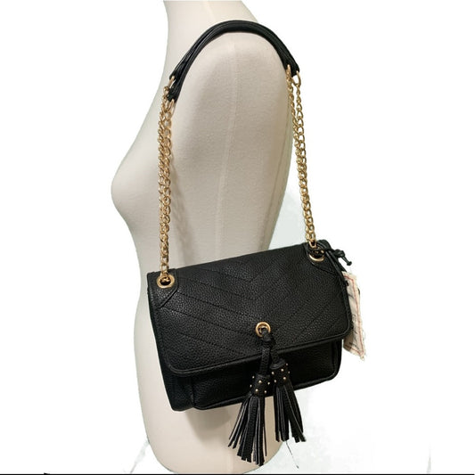 Front of Black handbag with gold chain strap and tassel on a mannequin.