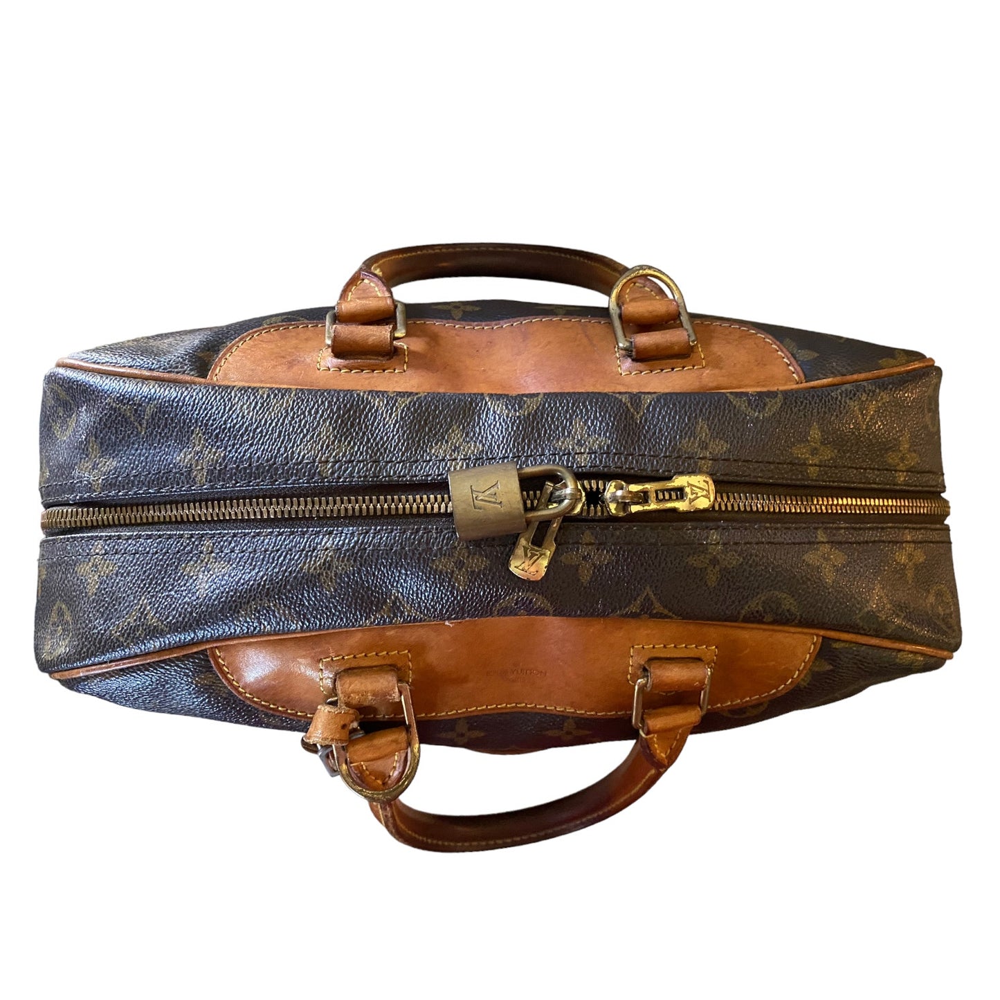 Top of Designer handbag with monogram pattern and gold hardware on a white background