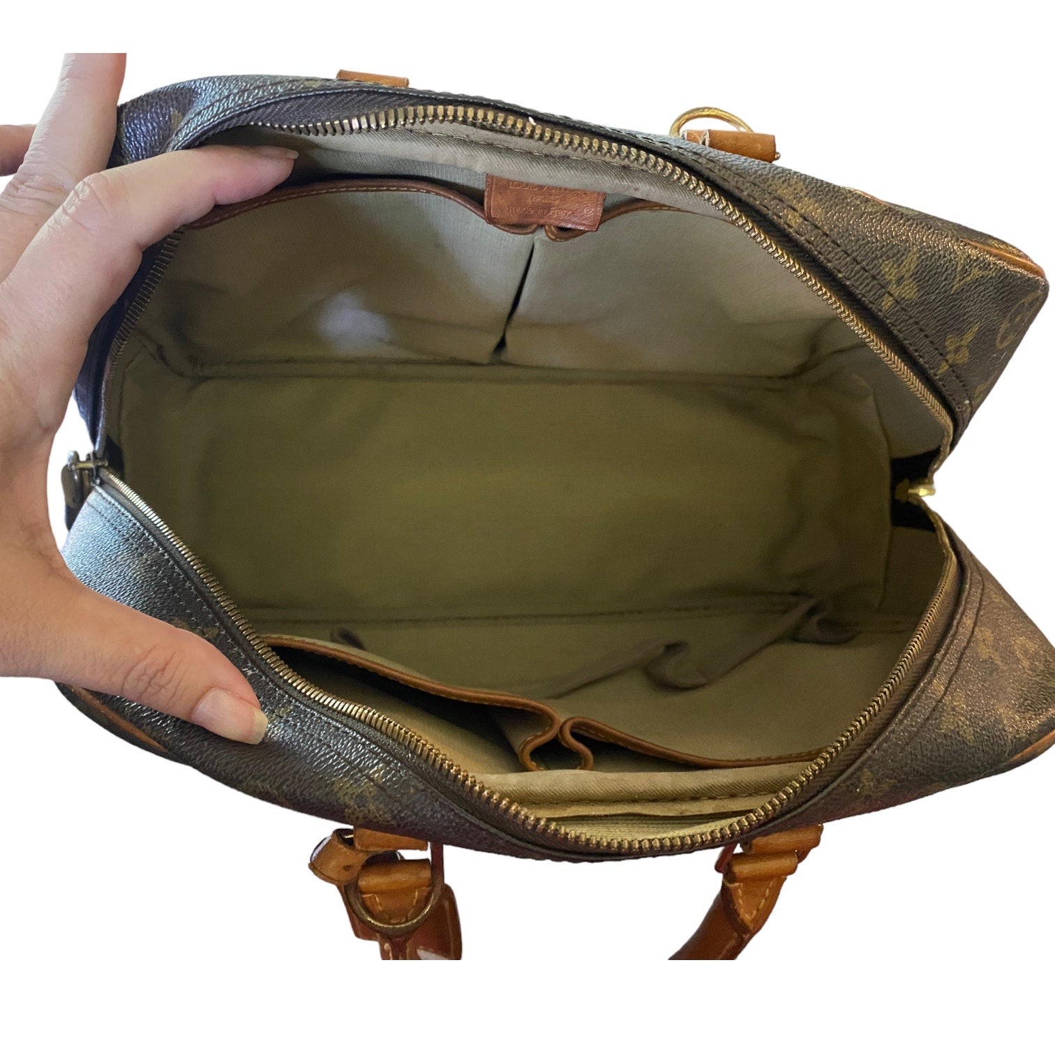 Brown bag with a hand opening it showing interior on a white background