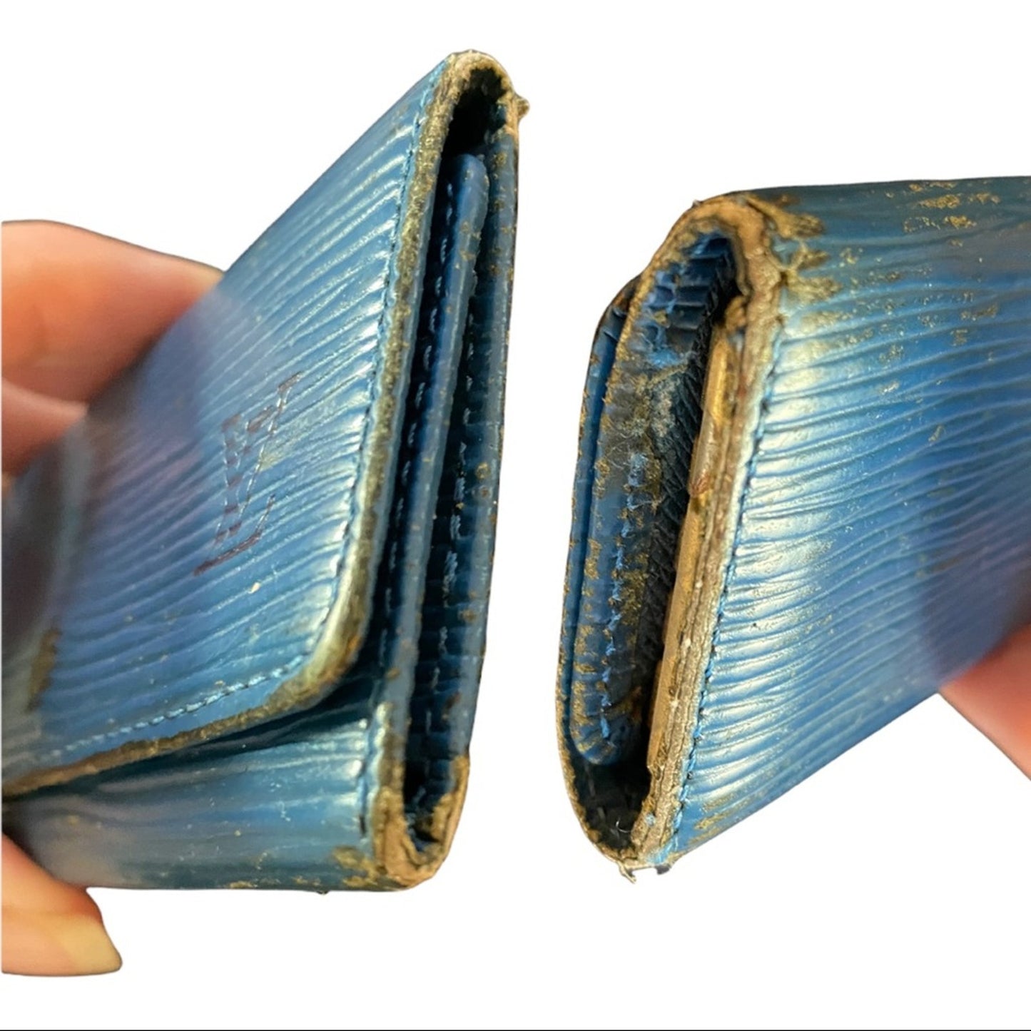 Side views of Blue textured wallet held open by a hand on a white background