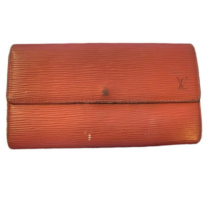 A vintage Louis Vuitton Epi leather clutch wallet in a reddish-brown color, featuring the embossed LV logo on the right side of the flap.