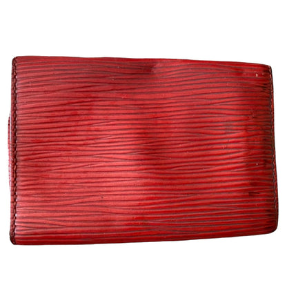 A red textured leather key wallet with horizontal grain, shown flat against a plain white background.