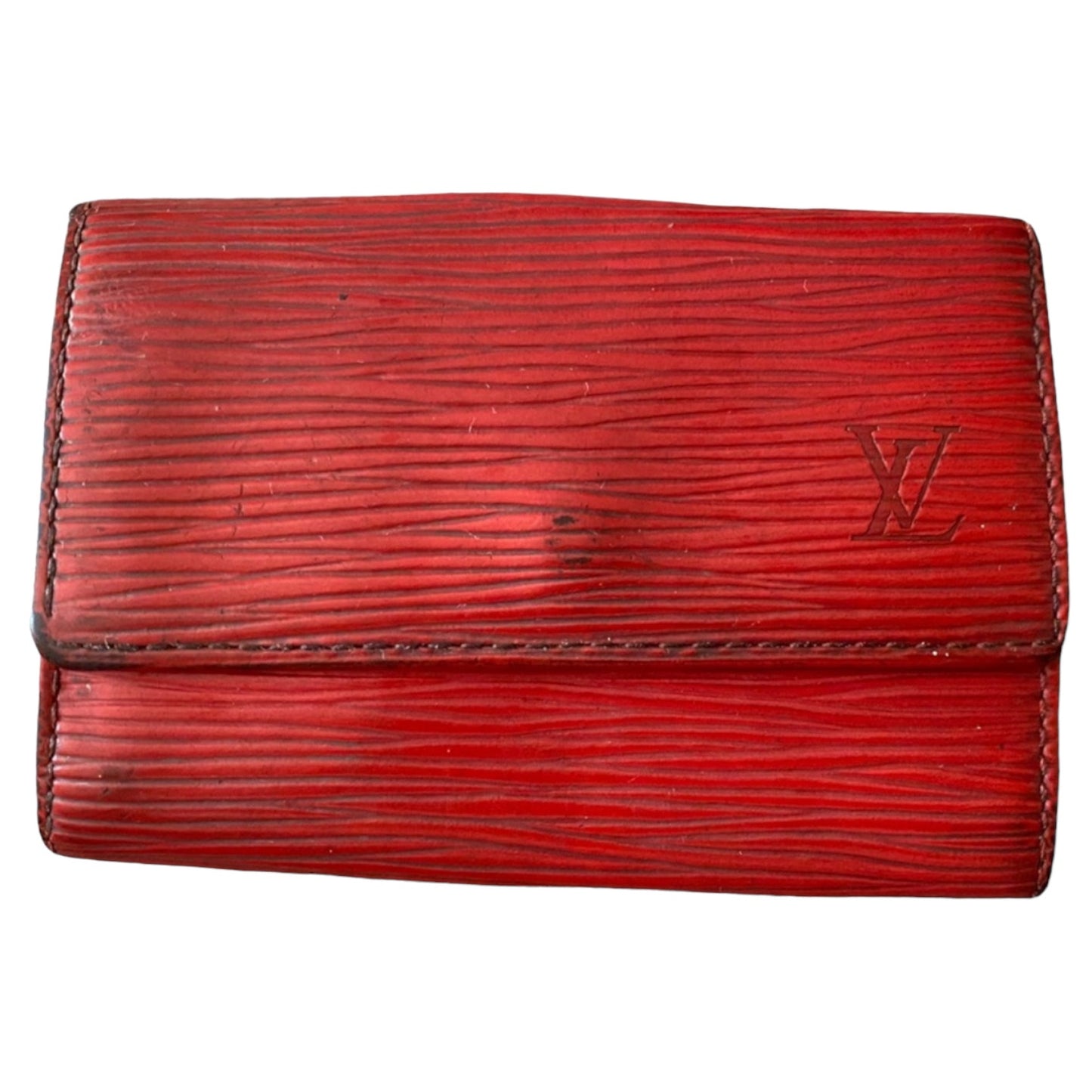 A red textured leather key wallet with an embossed Louis Vuitton LV logo on the front, set against a plain white background.