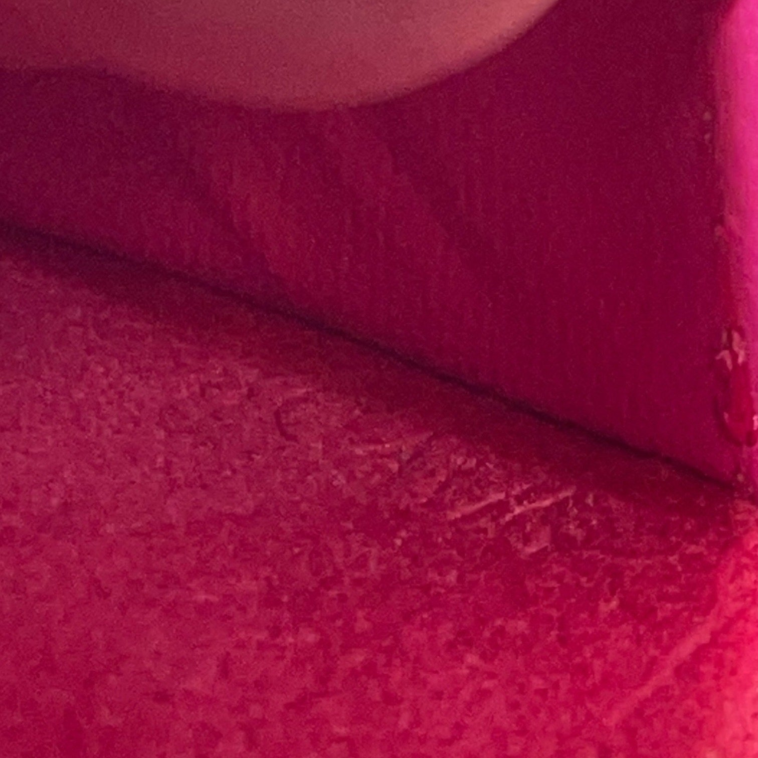 Close-up of a textured pink fabric with a subtle pattern and date code