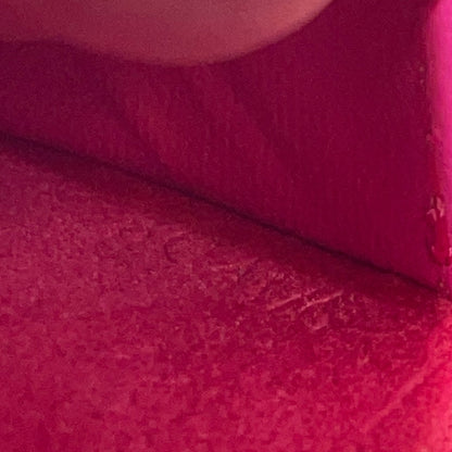 Close-up of a textured pink fabric with a subtle pattern and date code