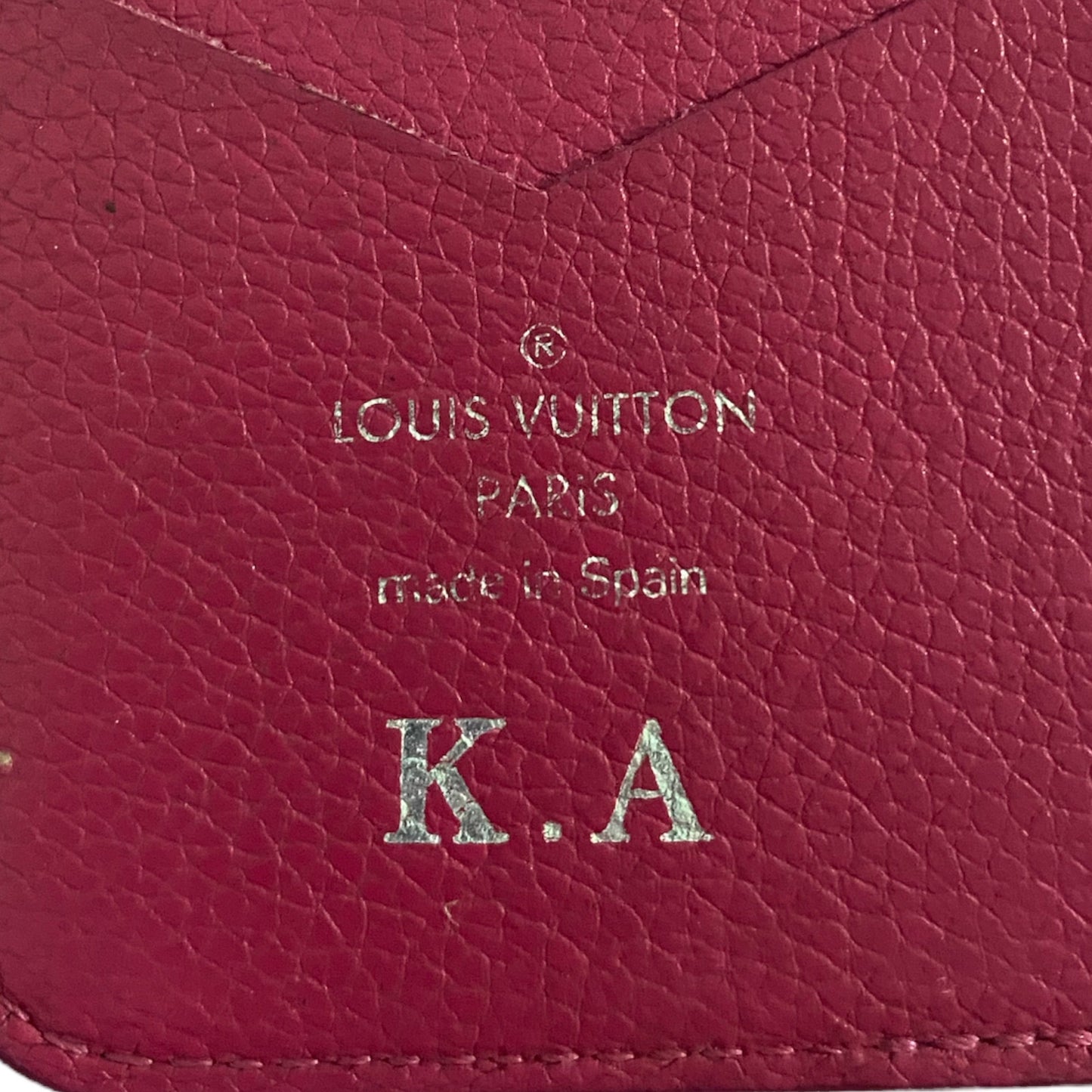 Close-up of a pink Louis Vuitton wallet with initials K.A.