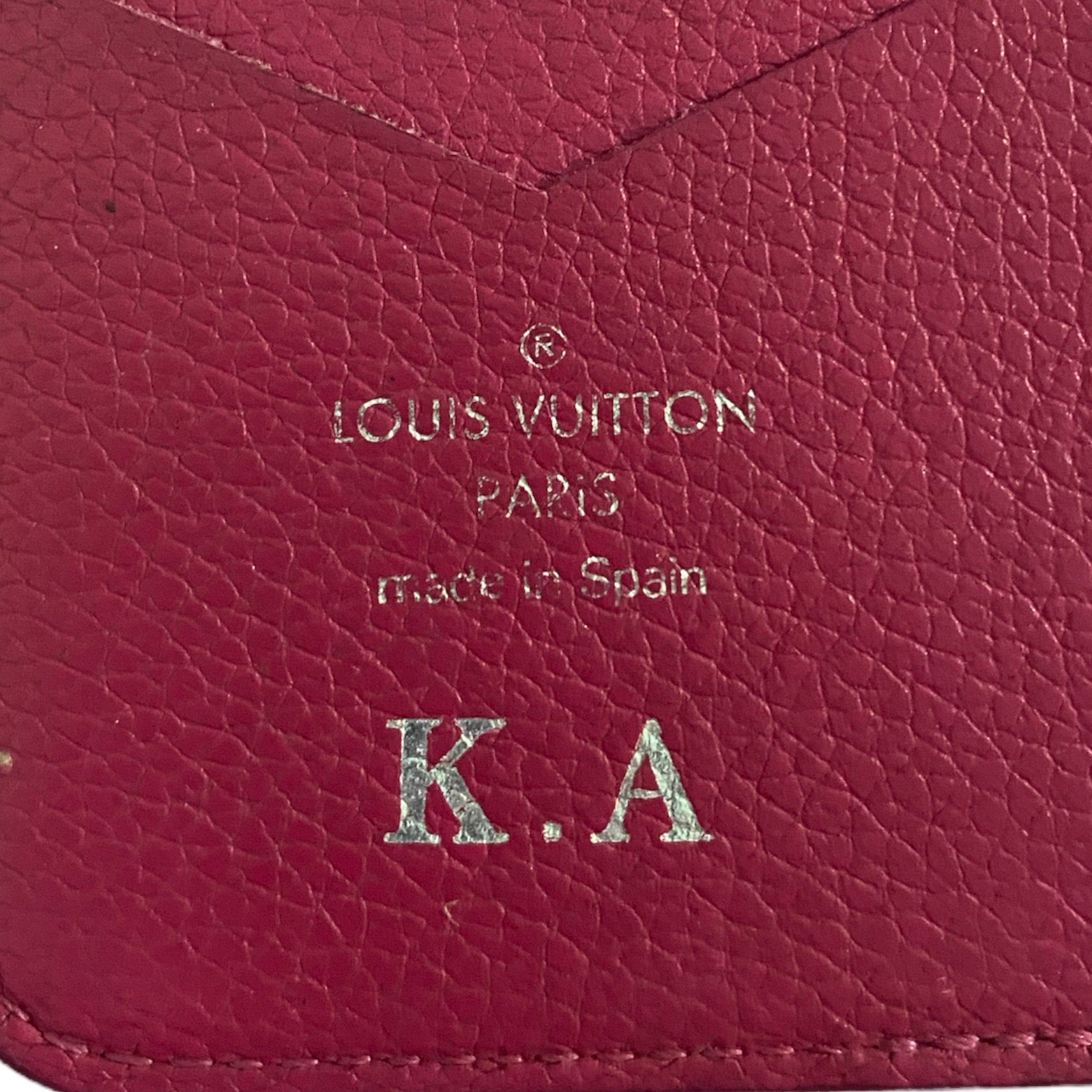 Close-up of a pink Louis Vuitton wallet with initials K.A.