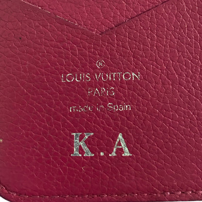 Close-up of a pink Louis Vuitton wallet with initials K.A.