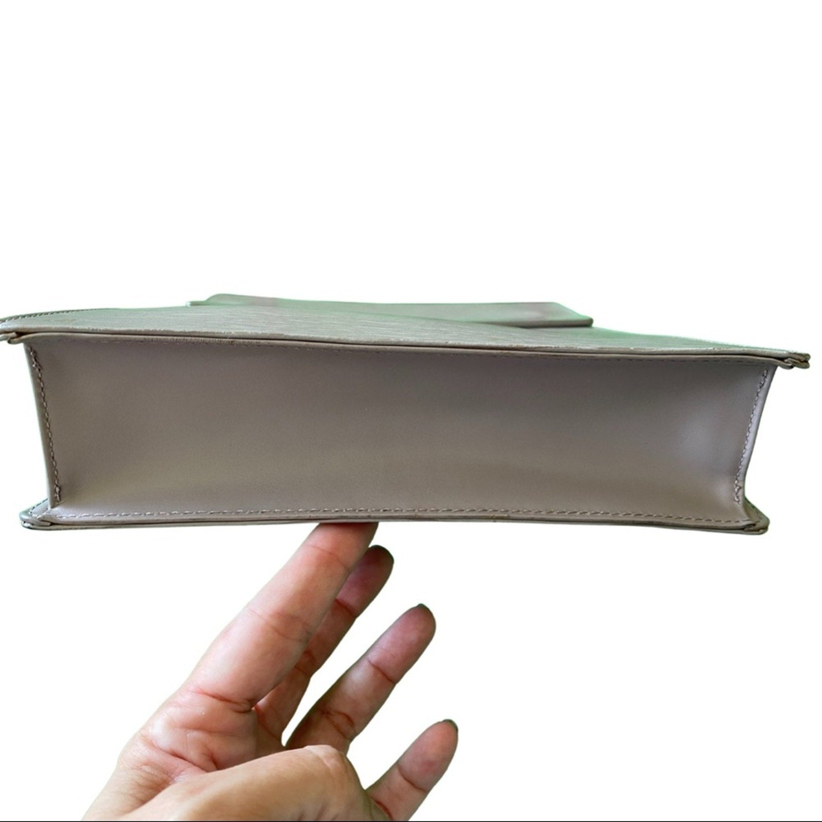 Bottom view of purple handbag against a white background