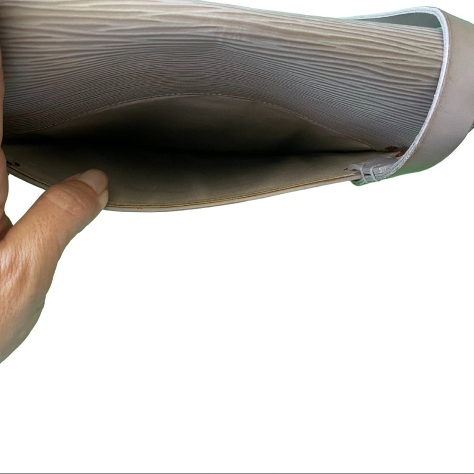 Close-up of a hand holding purple purse with a back pocket a white background