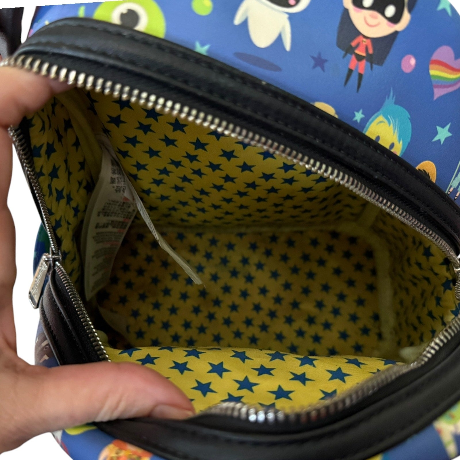 Colorful bag with cartoon characters and a yellow star-patterned interior.