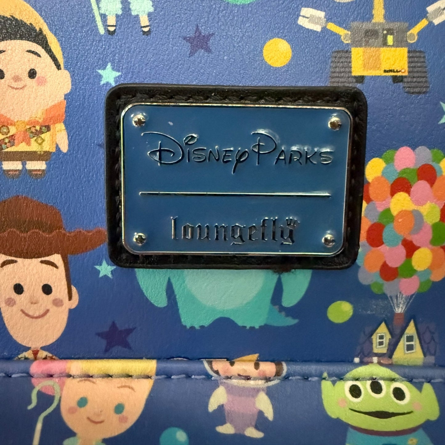Disney Parks Loungefly logo on a colorful background with cartoon characters.