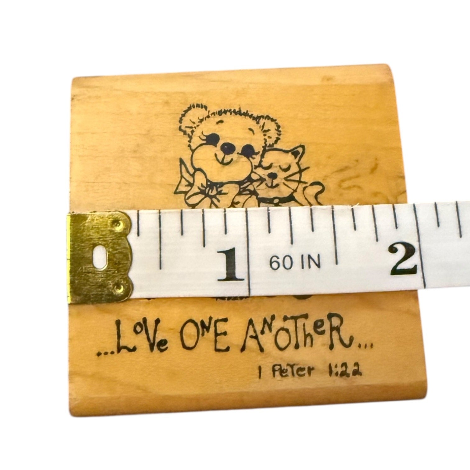 Wood block with measuring tape and text on a white background