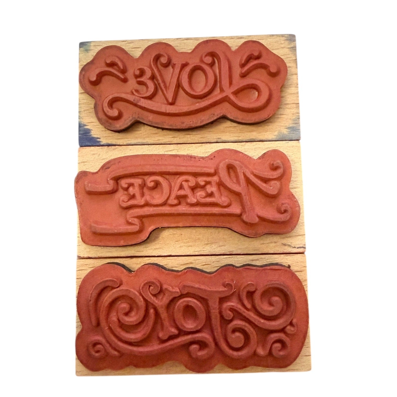 Three wooden stamps with engraved text on a wooden block.