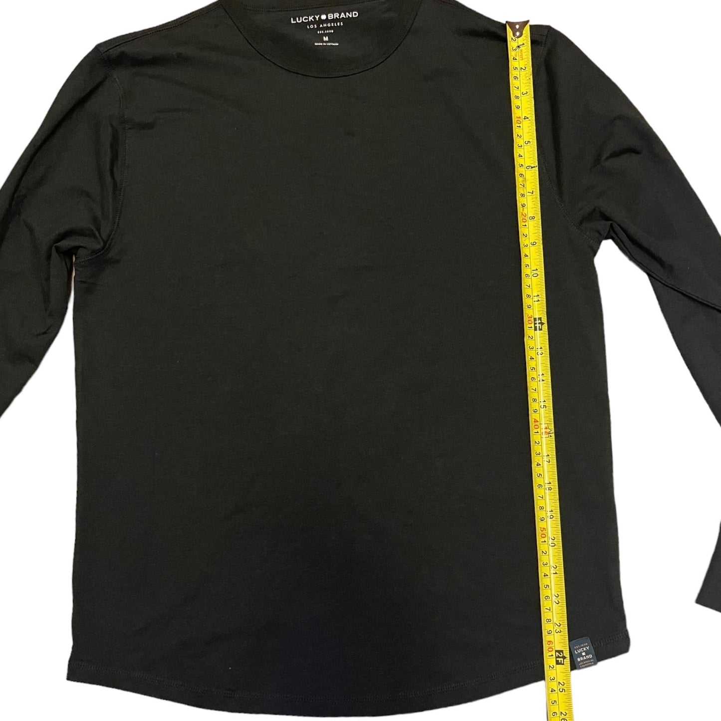 Black long-sleeve shirt with a measuring tape on a white background