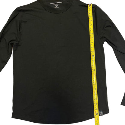 Black long-sleeve shirt with a measuring tape on a white background