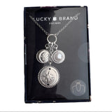 Silver necklace with charms on a Lucky Brand packaging