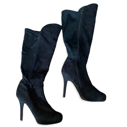 A pair of black knee-high boots with a suede-like finish, featuring a high stiletto heel and a side zipper, shown against a plain white background.