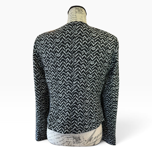 A black and white chevron pattern knit sweater displayed on a mannequin torso against a  white background.