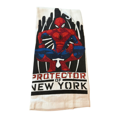 A towel featuring a graphic of Spider-Man crouching with the text 'PROTECTOR OF NEW YORK' printed below, set against a plain white background.