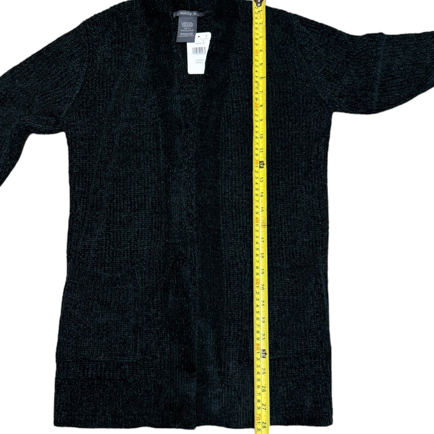 Green cardigan with a yellow measuring tape on a white background