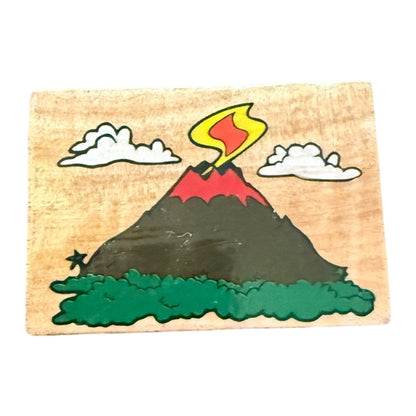 Wooden stamp with a volcano design on a white background