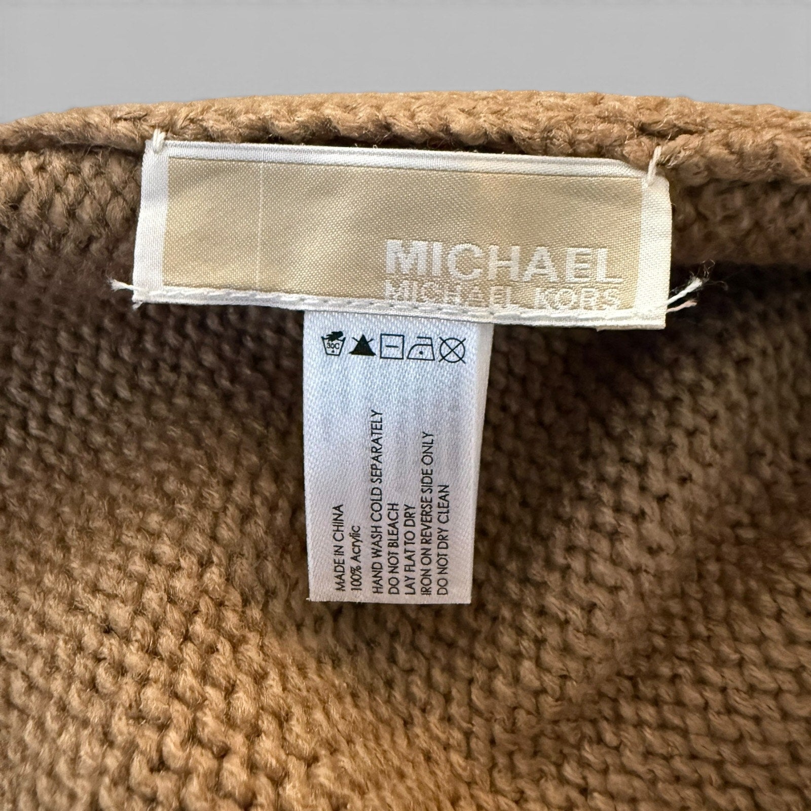 Close-up of a Michael Kors label on beige fabric