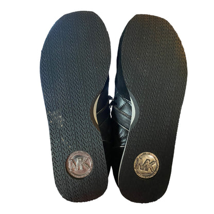 Black leather shoes with brand logo on soles against a white background