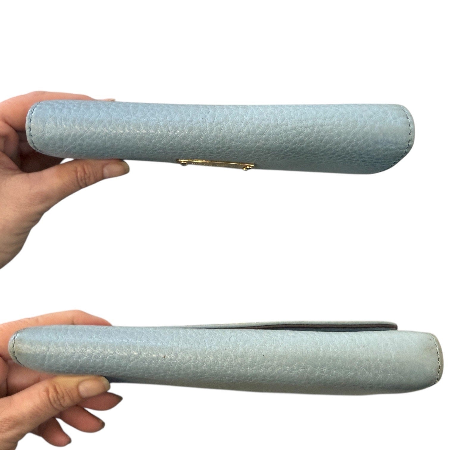 Top and bottom of Light blue textured wallet held by a hand on a white background