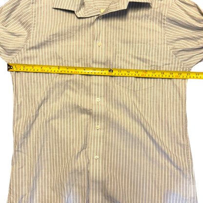 Blue striped shirt laying flat on the ground with a yellow measuring tape on a white background. 