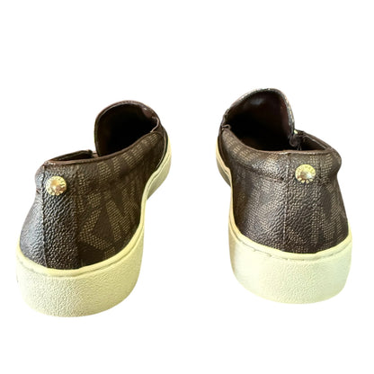 Back of brown MK sneakers with white soles on a white background