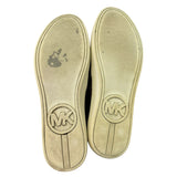 Shoe soles with Michael Kors logo on a white background