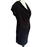 Black draped dress on a mannequin against a white background