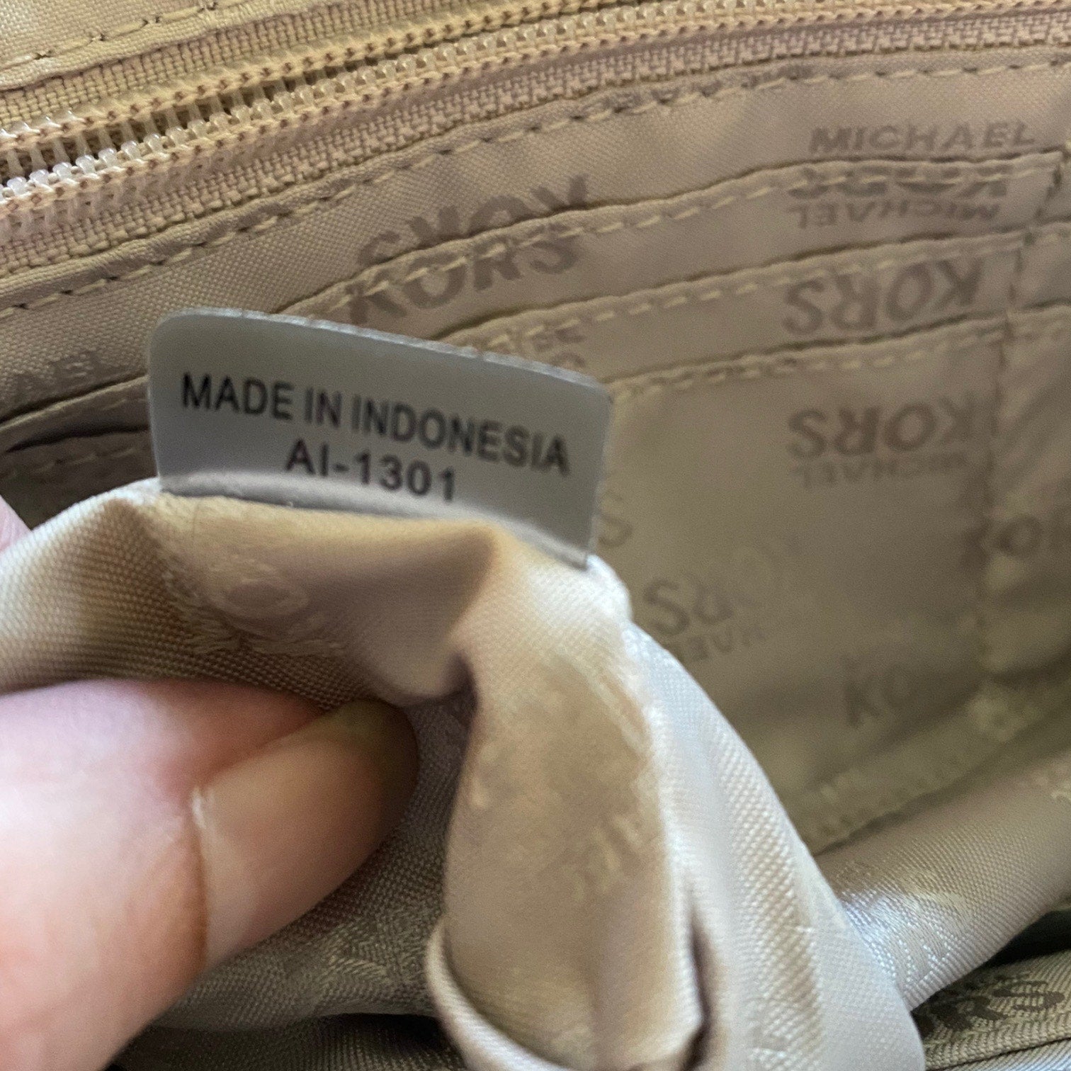 Close-up of Michael Kors handbag with a 'Made in Indonesia' label.
