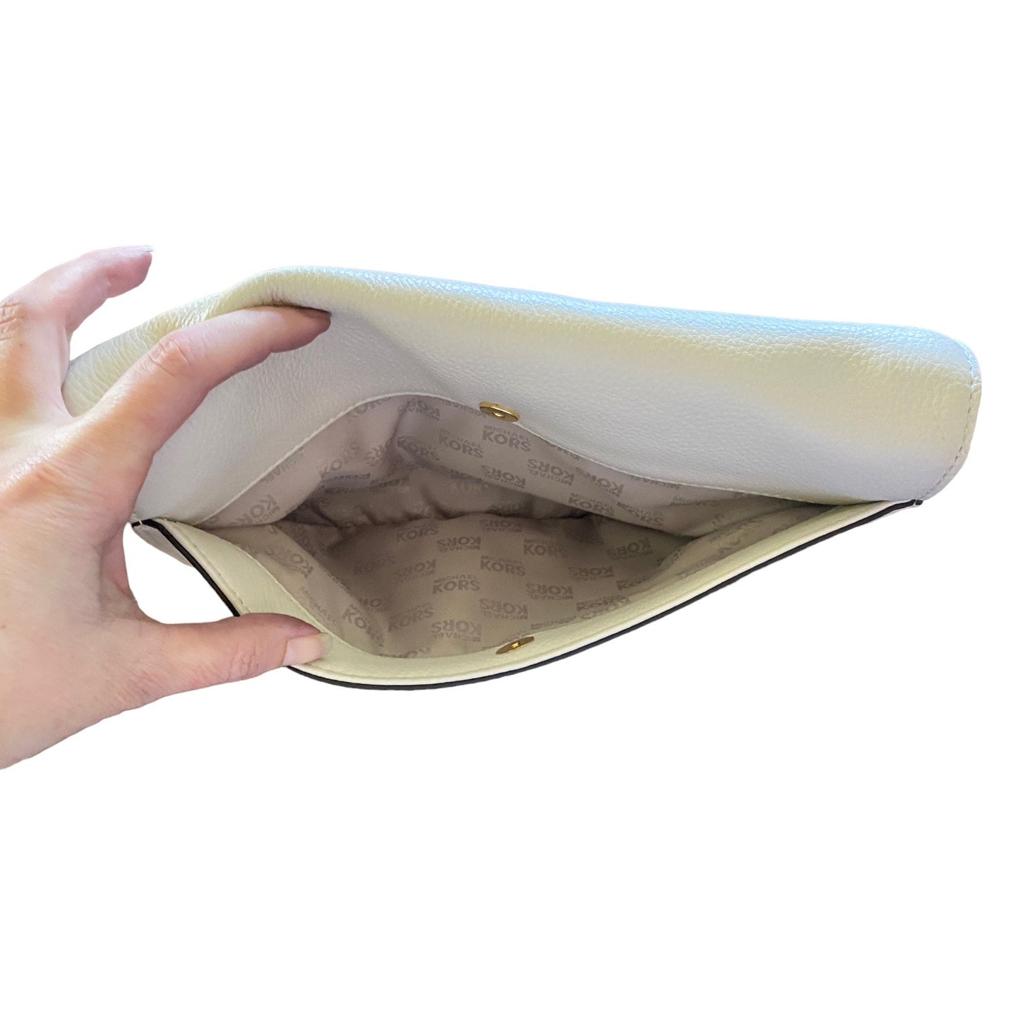 Hand holding open back pocket on purse against a white background
