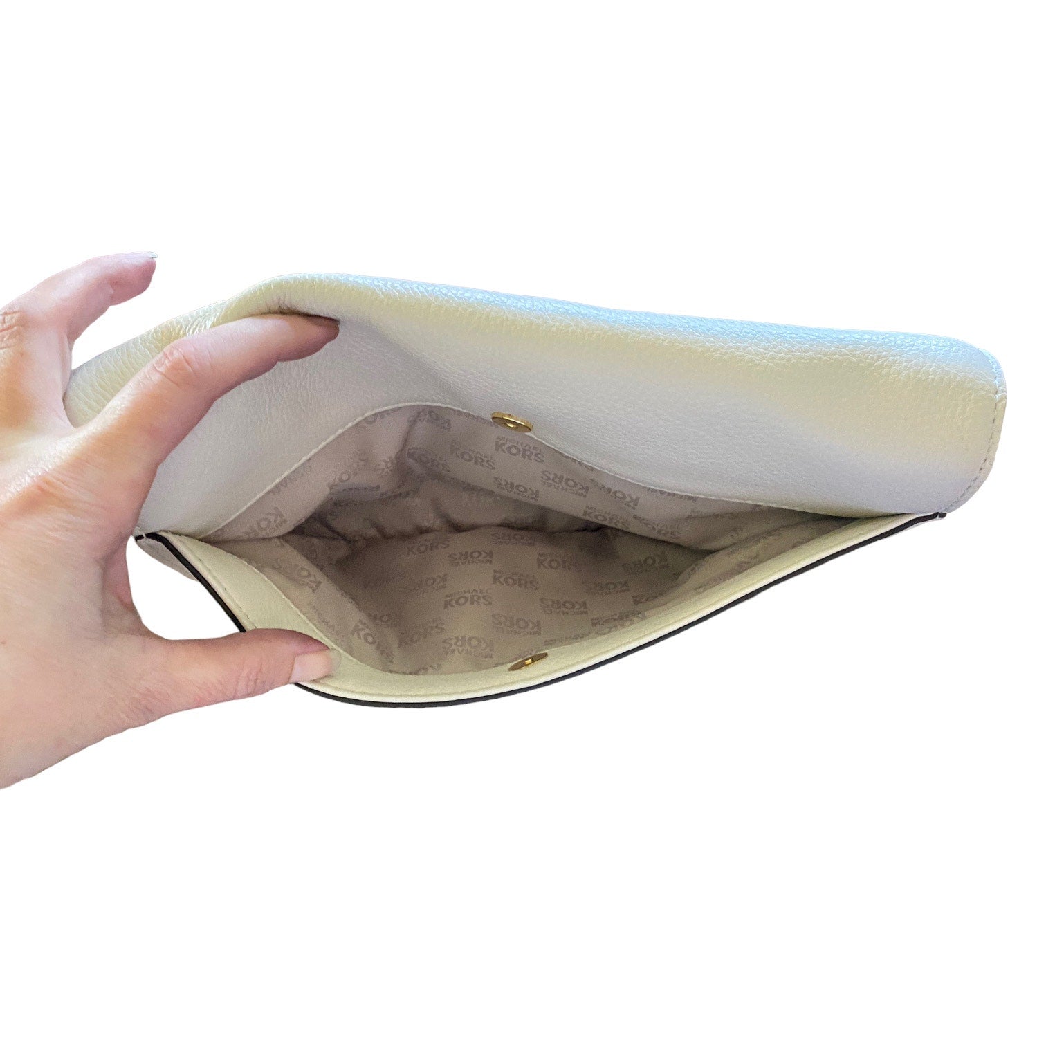Hand holding open back pocket on purse against a white background