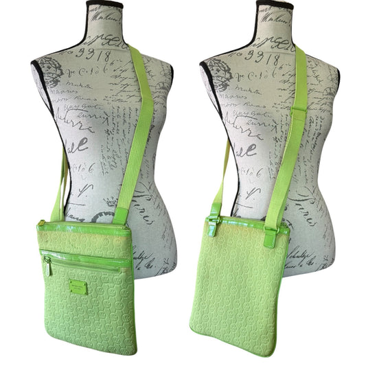 A light green crossbody bag with a textured front pocket and matching strap, shown on two vintage-style dress forms against a white background.