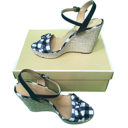 A pair of women's wedge sandals with  gingham check fabric uppers, ankle straps, and natural jute-wrapped wedge heels, displayed with a beige shoebox on a white background.