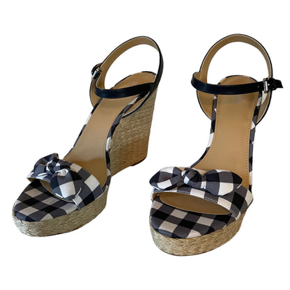 Front of gray and white checkered wedge sandals with bow details on a white background