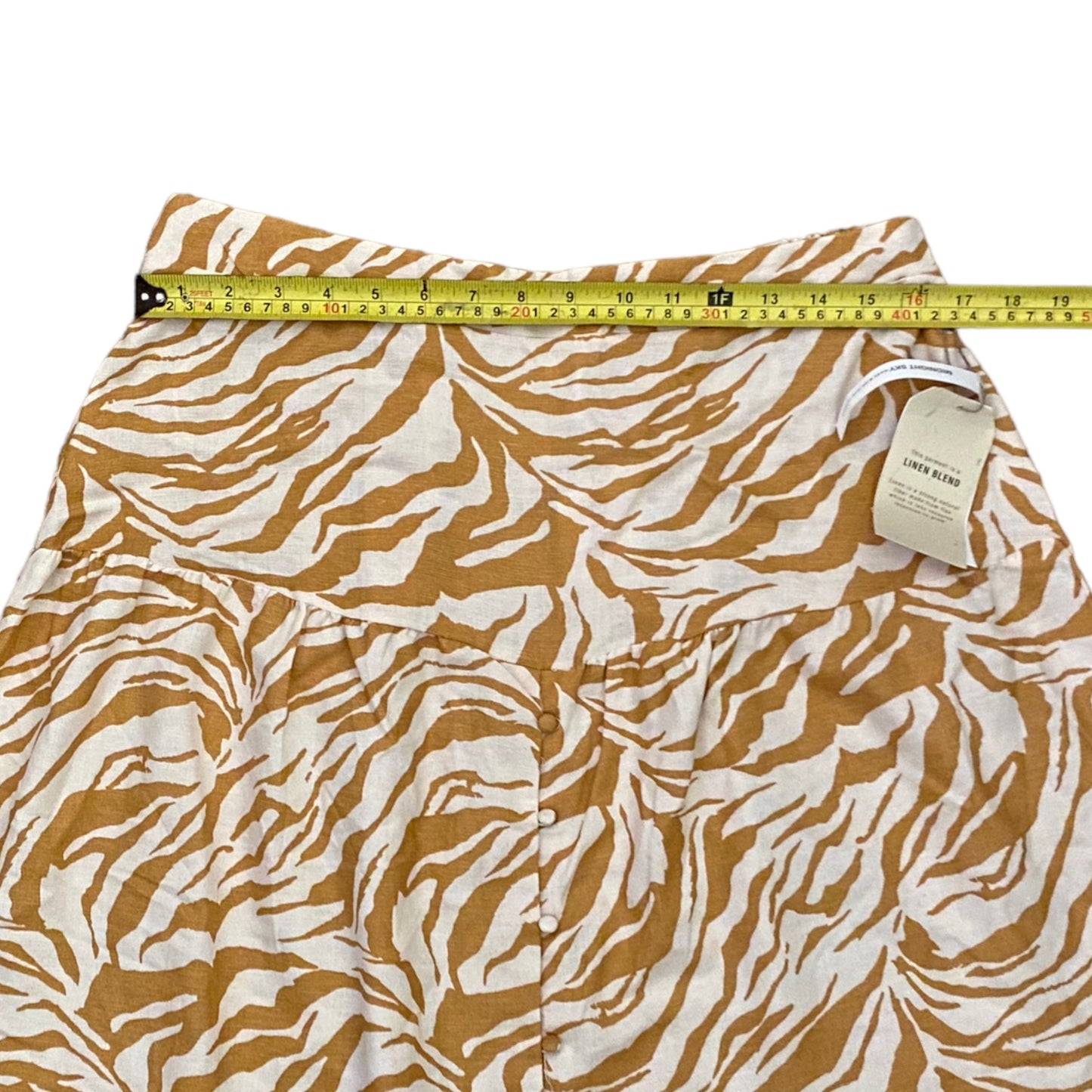 Skirt with brown and white pattern and measuring tape on a white background